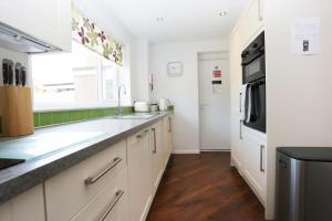 a kitchen with white cabinets and a sink and a window at BOURNECOAST: Stones throw from the Quay - HB5666 in Bournemouth