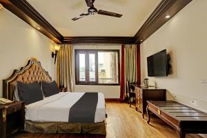 Habitación de hotel con cama y TV en Townhouse The Royce New Friends Colony, en Nueva Delhi