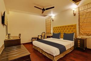 una camera d'albergo con letto e TV di Townhouse The Royce New Friends Colony a Nuova Delhi