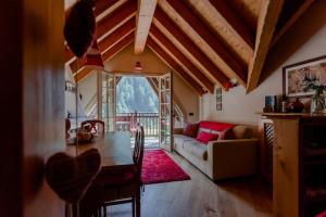un soggiorno con un tavolo e un divano di Casa di Beatrice a Ponte di Legno