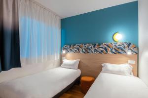 two beds sitting next to each other in a room at Aparthotel Adagio Access Paris La Villette in Paris