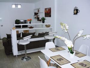 ein Esszimmer mit einem Tisch, Stühlen und einem Regal in der Unterkunft Apartament Sunny Holiday in Mamaia Nord – Năvodari