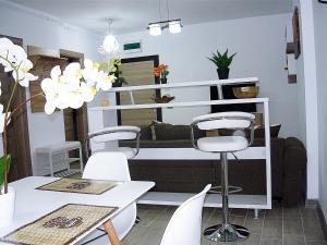 una sala da pranzo con tavoli bianchi e sedie bianche di Apartament Sunny Holiday a Mamaia Nord - Năvodari