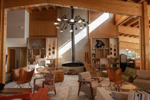 een grote woonkamer met een open haard en stoelen bij Big Sky Hotel in Chamonix-Mont-Blanc