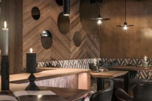 a restaurant with wooden walls and wooden tables and chairs at SonnenHOF hotel gerlos centrum in Gerlos +154 photos