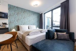 a bedroom with a bed and a table and a couch at The Doorman Goethe Frankfurt am Main in Frankfurt