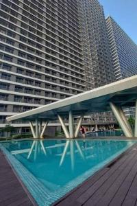 a swimming pool in front of a large building at Lovely Fame7Roses in Manila