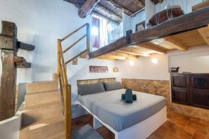 サンタ・ヘルトゥルディス・デ・フルテラにあるAgroturismo Can Marquet - Adults Onlyの階段のある部屋にベッドルーム1室(ベッド1台付)