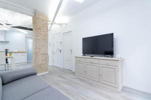 a living room with a flat screen tv on a white cabinet at Piso en el Centro de Zaragoza, Parking GRATIS, Check-in 24h in Zaragoza