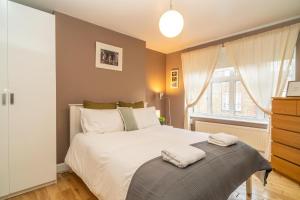 een slaapkamer met een bed en een raam bij Location! 2 bed/2bath - Pro Host in Londen