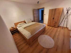 1 dormitorio con 1 cama y suelo de madera en Bergblick Wohnung Posch, en Imst