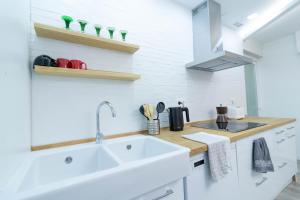 a white kitchen with a sink and a counter at Piso en el Centro de Zaragoza, Parking GRATIS, Check-in 24h in Zaragoza +16 photos
