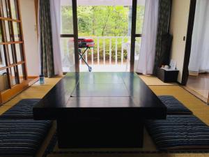 a black coffee table in a room with a balcony at 森の中のぽつんとワンワン別荘 in Nikko