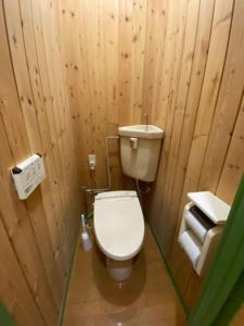 baño de madera con aseo y lavamanos en 森の中のぽつんとワンワン別荘, en Nikko