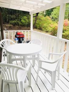 a white table and chairs on a porch at 森の中のぽつんとワンワン別荘 in Nikko