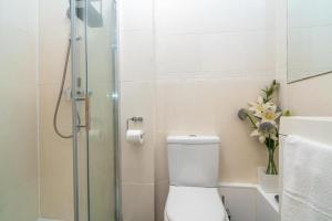 a bathroom with a toilet and a glass shower at Location! 2 bed/2bath - Pro Host in London