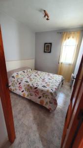 a bedroom with a bed with a flowered blanket on it at Dúplex Bornoi in Vinarós