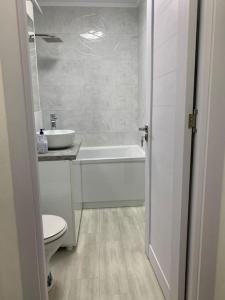 uma casa de banho com um WC, uma banheira e um lavatório. em Apartament in complex rezidențial em Râmnicu Vâlcea