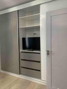 um quarto com uma televisão e uma porta de vidro deslizante em Apartament in complex rezidențial em Râmnicu Vâlcea