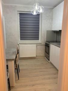 uma cozinha com uma mesa e uma janela em Apartament in complex rezidențial em Râmnicu Vâlcea