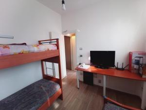 a room with a desk with a computer and a bunk bed at Alcova Nicolò Biondo in Modena