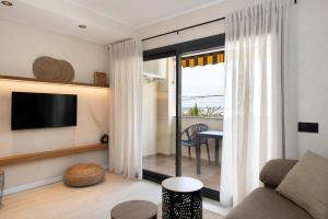 a living room with a couch and a television at MarPlana in Castelldefels