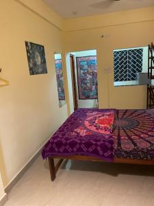 sypialnia z łóżkiem z fioletową kołdrą w obiekcie NO NAME GUESTHOUSE w mieście Arambol