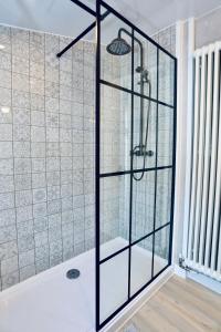 a shower with a glass door in a bathroom at Caboodles Cottage in Crickhowell