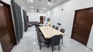 Villa Fatima في سيتياوان: غرفة طعام مع طاولة وكراسي طويلة