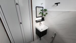 a white bathroom with a sink and a mirror at Villa Fatima in Sitiawan +25 photos