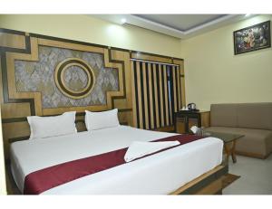 Hotel Shree International, Muzaffarpur في مظفربور: غرفة نوم بسرير كبير وأريكة