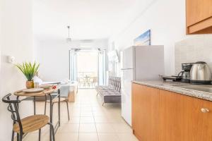 a kitchen with a table and a refrigerator at Urban Apt Next University 20 in Heraklio