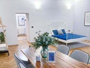 uma sala de estar com uma mesa e uma cama em Best Price & Location - Historic Square Residency em Praga