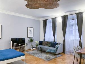 a living room with a blue couch and a table at Best Price & Location - Historic Square Residency in Prague