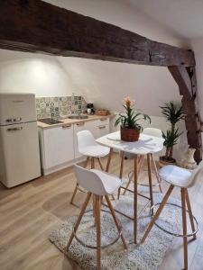 eine Küche mit einem Tisch und Stühlen sowie einem Kühlschrank in der Unterkunft Appartement cocooning in Solre-le-Château