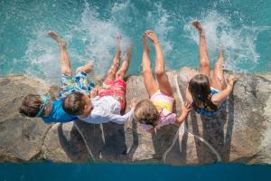 four people laying on a rock near the water at Centara Mirage Beach Resort Dubai in Dubai +203 photos