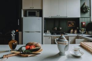 a kitchen with a table with a bowl of fruit and a kettle at Elegant apartment with balcony and free parking in Melbourne