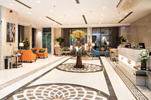 a lobby of a hotel with orange and blue chairs at Jiwar Hotel in Jeddah