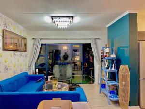a living room with a blue couch and a table at Idesel Apartment in Edendale