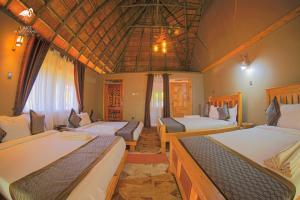 a room with two beds in a room with at Lake Munyanyange Caves Lodge in Kasese