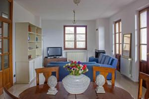 Villa gli Ulivi - Fivizzano في فيفيزانو: غرفة معيشة مع أريكة زرقاء وطاولة