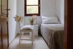 Un dormitorio con una cama y una silla y una ventana. en Villa gli Ulivi - Fivizzano, en Fivizzano 37 fotos más