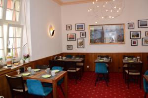 een eetkamer met tafels en stoelen en een kroonluchter bij Hotel Barbara in Freiburg im Breisgau