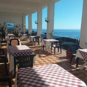 ジャルディーニ・ナクソスにあるホテル オルフェウスのテーブルと椅子が備わり、海の景色を望むレストラン