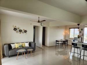 a living room with a couch and a table at Trinity Stays Nashik - Mountain view apartment close to Sula in Nashik