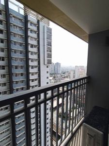 a balcony with a view of a city with tall buildings at Lovely Fame@4T in Manila