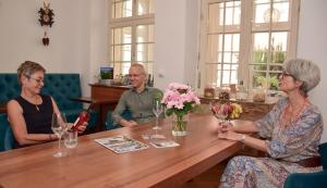 Un groupe de personnes assises autour d'une table dans l'établissement Hotel Barbara, à Fribourg-en-Brisgau