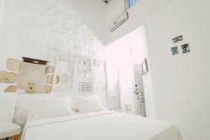 a white bedroom with a bed and a window at YUKARI SOKAK VİP BUTİK OTEL in Alacati