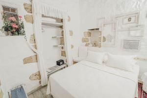 a white bedroom with a bed and a mirror at YUKARI SOKAK VİP BUTİK OTEL in Alacati