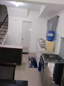 una pequeña cocina con fogones y una escalera en Vacation home in Lancaster new city Cavite Philippines en General Trias